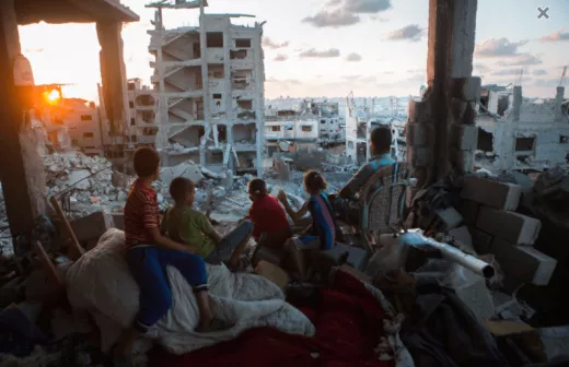 Een Palestijns gezin kijkt vanuit de ruïnes van hun huis naar de opkomende zon in de wijk at-Tuffah in Gaza-stad, kort na de bombardementen door het Israëlisch leger tijdens Operation Protective Edge in 2014. Foto: Anne Paq/activestills.org 