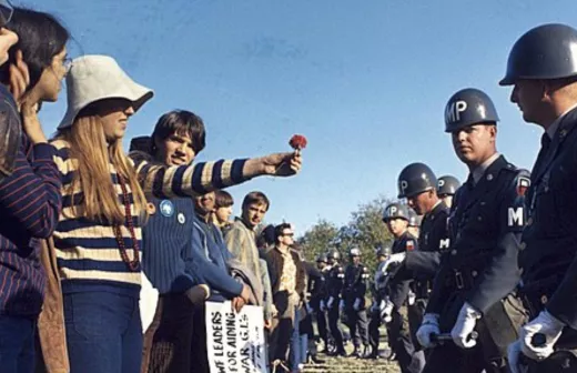 Een demonstrant geeft een bloem aan de politie tijdens anti-Vietnam oorlog protesten in de VS (1967). Foto: Wikimedia Commons/Public Domain. 