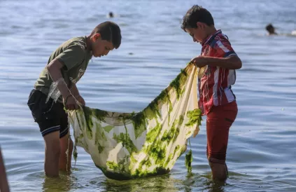 Twee Palestijnse jongens proberen wat vis te vangen aan de kust van Gaza. Het water is er ernstig vervuild. Foto: Mohammed al-Hajjar/ICRC
