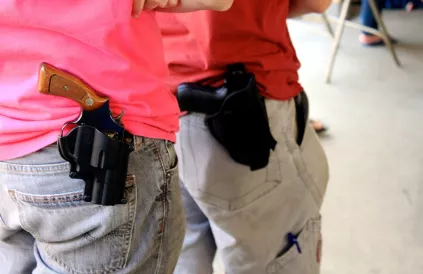 Twee personen dragen openlijk een holster met revolver in de staat New Hampshire, een van de 30 staten waar dat wettelijk mag. Foto: Lucio Eastman / CC BY 2:0