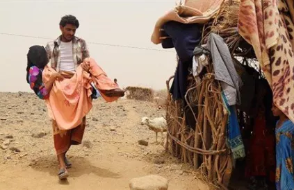 Fatima Ibrahimn al-Marzuqi wordt door haar broer naar de medische hulppost gedragen voor verzorging. Zij kan niet meer stappen sinds ze in haar dorpje Malus op een clusterbom trapte. Foto: Ole Solvang/Human Rights Watch