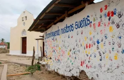 Geschilderde kinderhandjes op een schoolmuur 'We bouwen onze dromen terug op'. Foto: www.resumenlatinoamericano.org/