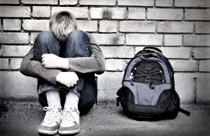 upset boy against a wall