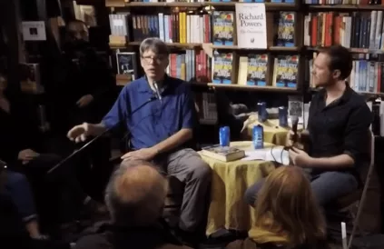 Richard Powers (l) tijdens een lezing over zijn boek op 1 oktober 2018. Screenshot YouTube Shakespeare and Company Bookshop