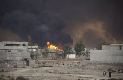 Uitslaande brand na VS-bombardementen in een wijk van Mosoel. Foto: 