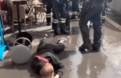 Een passerende jongedame, niet eens een betoger, wordt keihard tegen de grond gesmakt door de politie. Symbolischer kan niet. Screenshot Twitter @Poulin2012
