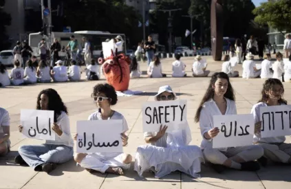 Vrouwen houden borden in het Arabisch, Hebreeuws en Engels vast tijdens een demonstratie van Israëlische en Palestijnse vrouwen waarin wordt opgeroepen tot vrede, in Tel Aviv, Israël, 15 december 2023. Foto: Morning Star.