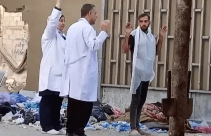 Directeur van het Kamal Adwan-ziekenhuis, Hussam Abu Safiyeh (midden), houdt zijn handen omhoog tijdens de Israëlische invasie van het ziekenhuis, 26 oktober 2024. Foto: Screenshot via Sociale media 