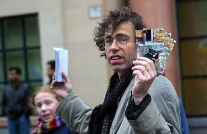 Tijdens de grootste betoging aller tijden, op 15 februari 2003 liep een activist in de regen postkaarten te verkopen voor het BRUSSELLS TRIBUNAL , een soort Russell tribunaal tegen de illegale invasie van Irak, onder het toeziend oog van zijn oudste docht