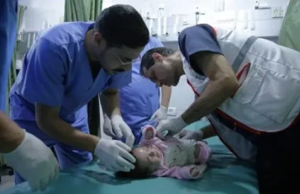 Dokter Ahmed Muhanna (r) verzorgt een baby (oktober-november 2023). Foto: AWDA