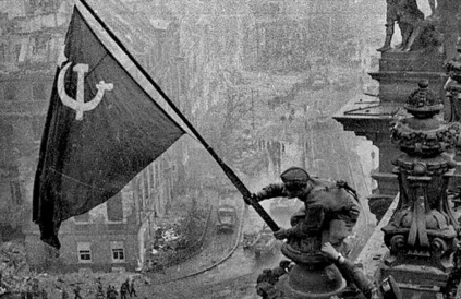 Op 2 mei 1945 werd boven het Reichstag-gebouw in Berlijn de rode vlag gehesen en een week later kwam Wereldoorlog II tot een einde. In sommige landen is deze foto verboden. Foto: TASS / Yevgeny Khaldei, Wikimedia Commons / CC BY 4.0