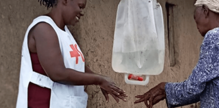 Twee vrouwen van het Rode Kruis in een Afrikaans land wassen hun handen.