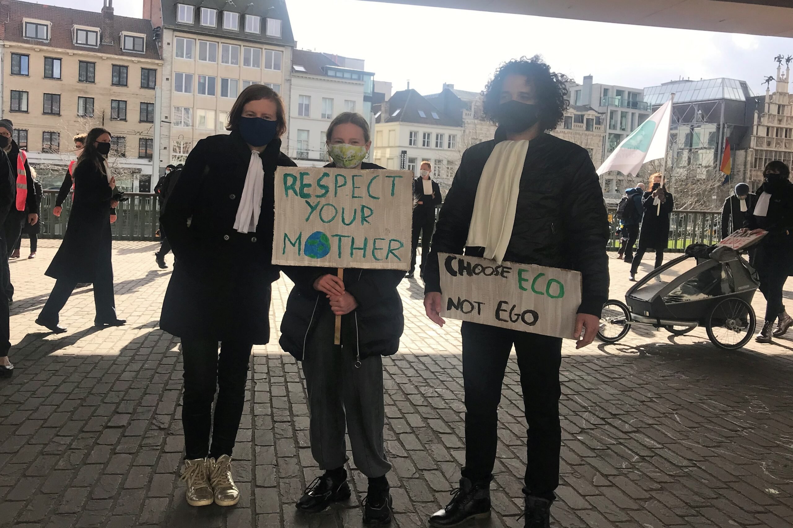 3 klimaatadvocaten met protestborden "respect our mother"